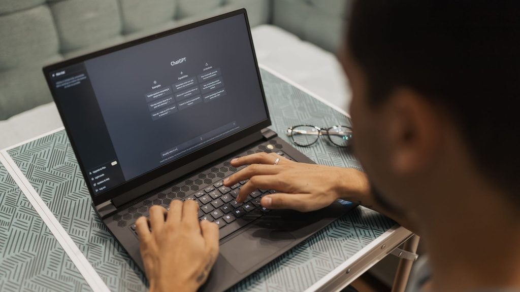 Osoba korzystająca z ChatGPT na laptopie – sztuczna inteligencja jako narzędzie wspierające interpretację wyników badań online
